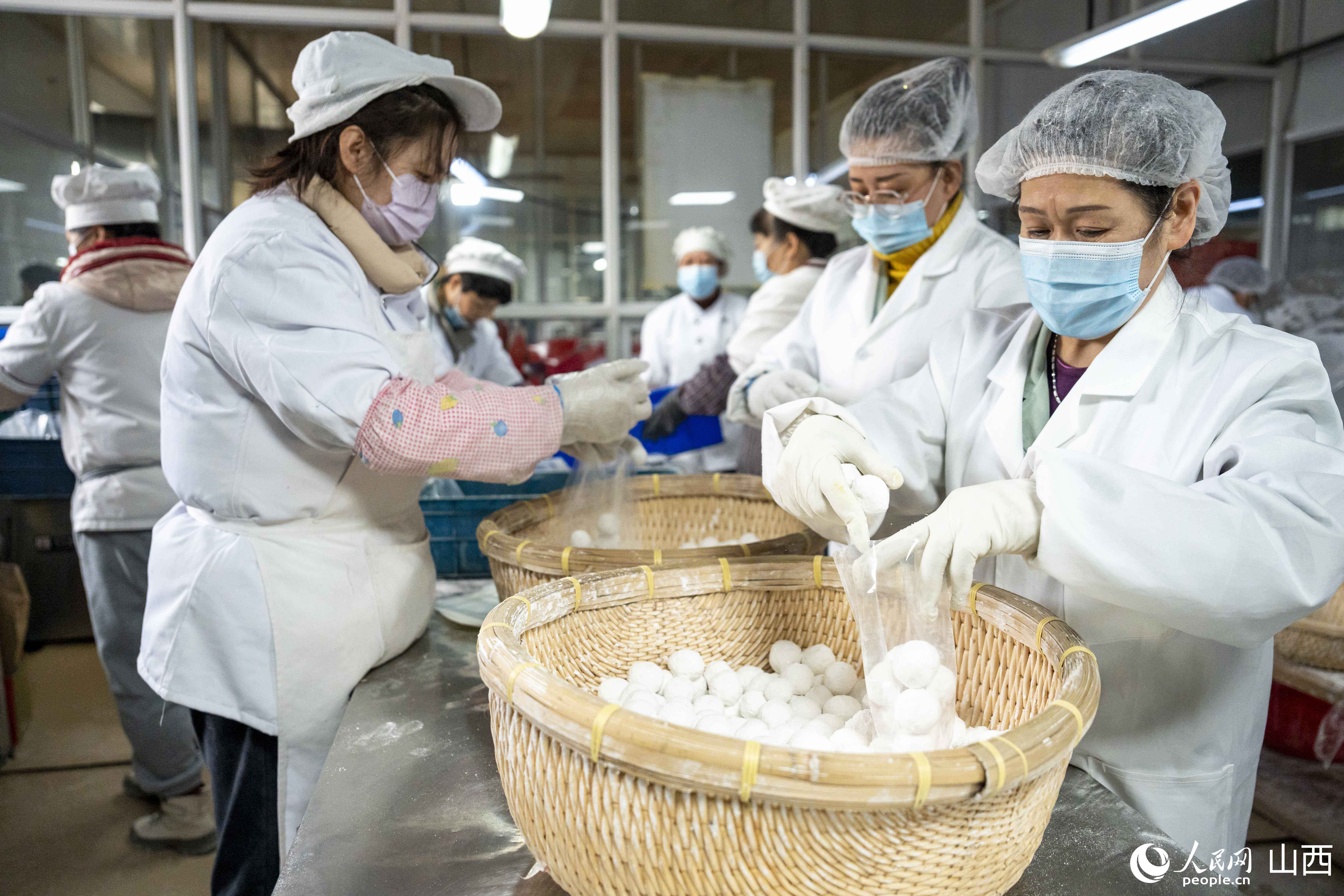 工人們正在分裝元宵。人民網盧鵬宇?攝