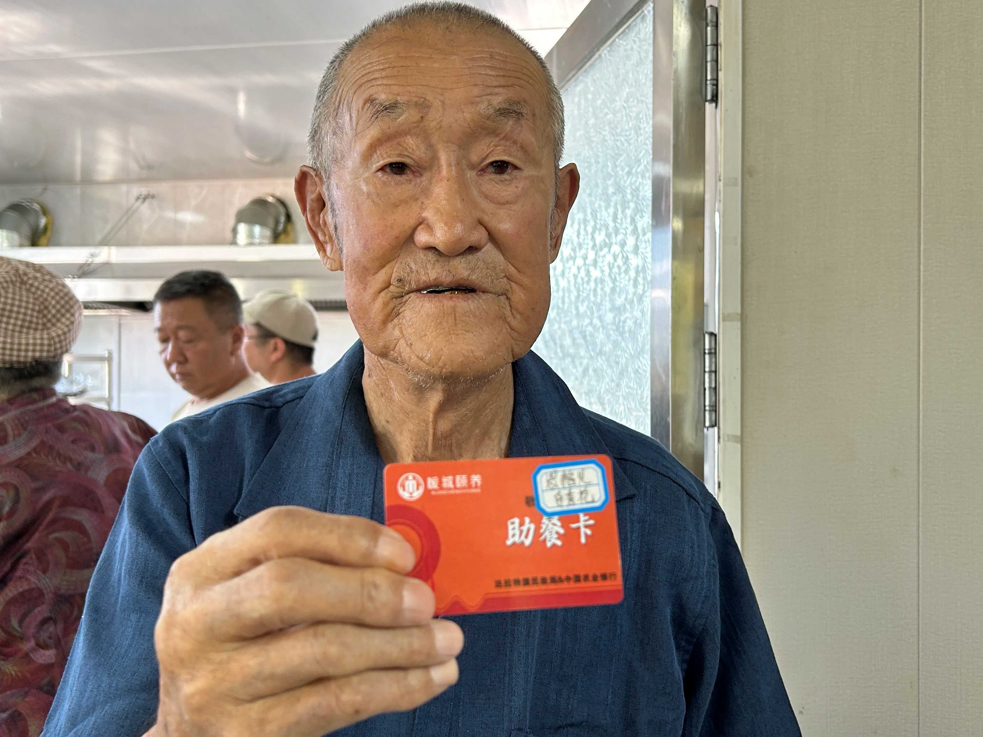 周銀栓老人向記者展示老伴兒的助餐卡。人民網 鄭莉茵攝