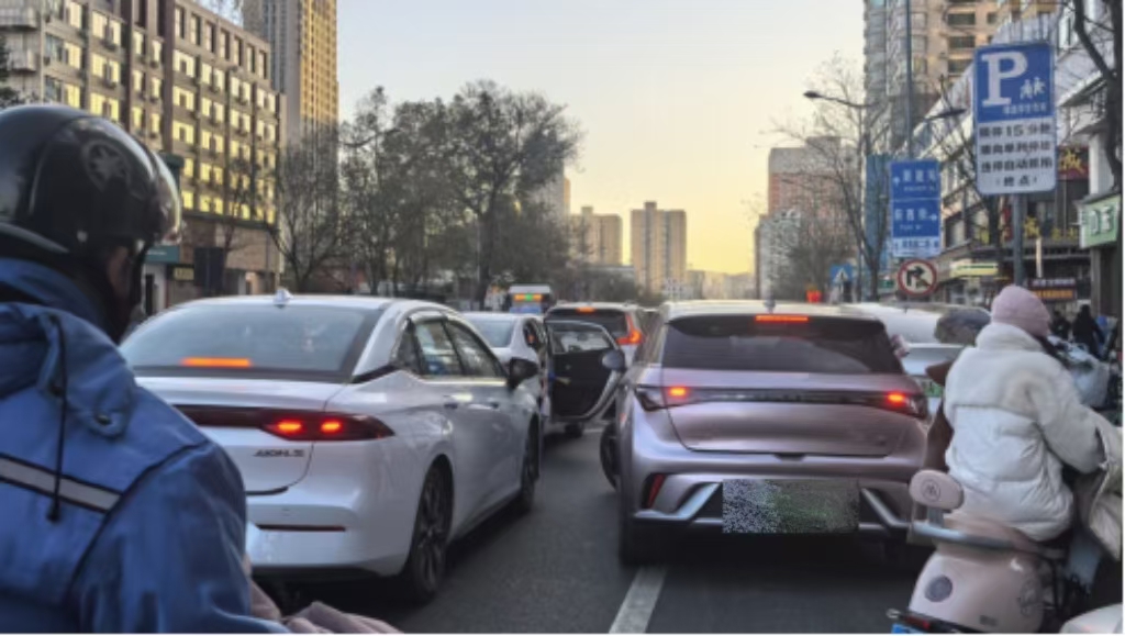 旱西關街旱西關南二條路口，送學車輛在直行車道停車下人。車門推開時，后方粉色車輛剛剛向左前方起步，險些發生磕碰。人民網記者王晏如攝