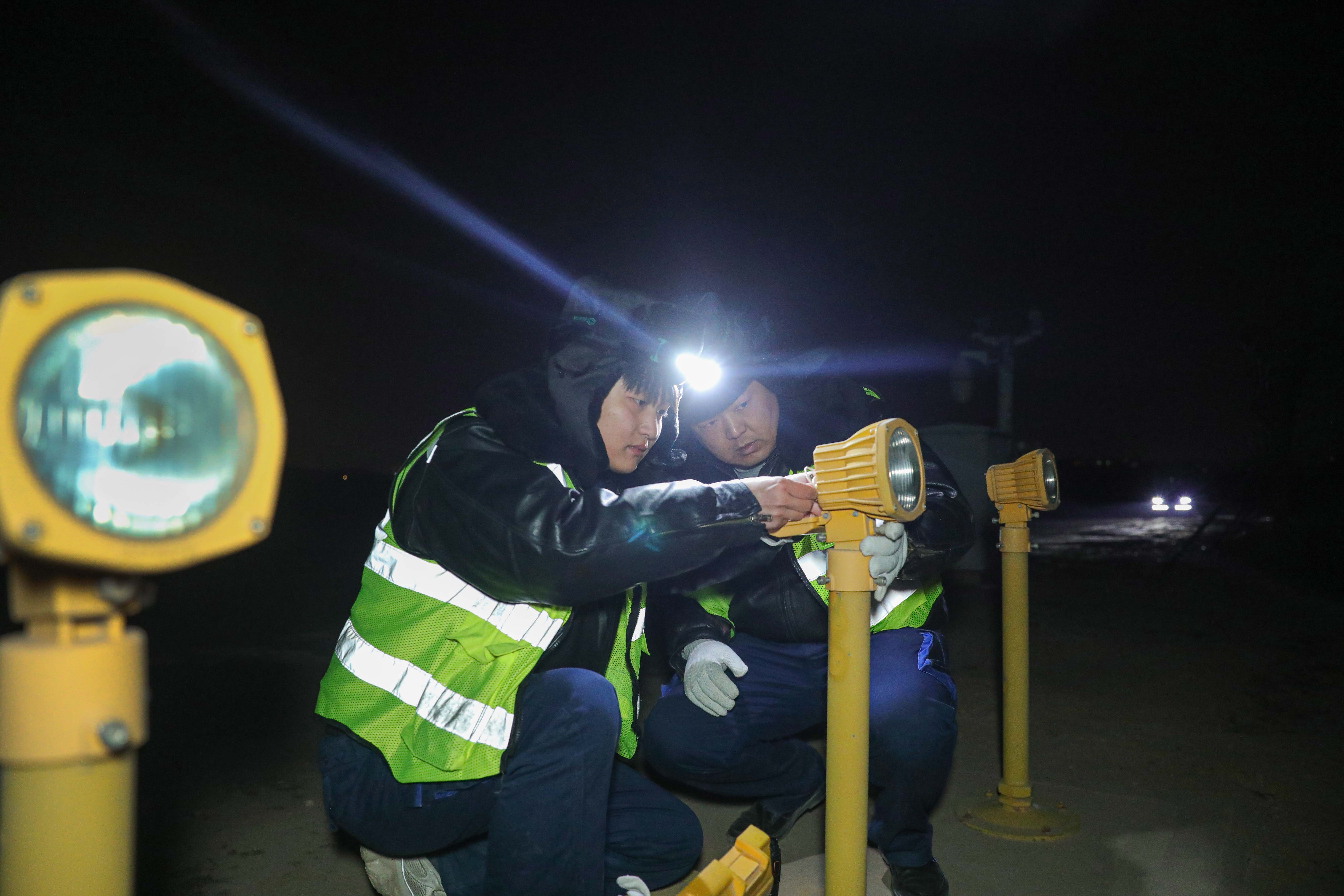 路偉和同事檢修故障燈具。