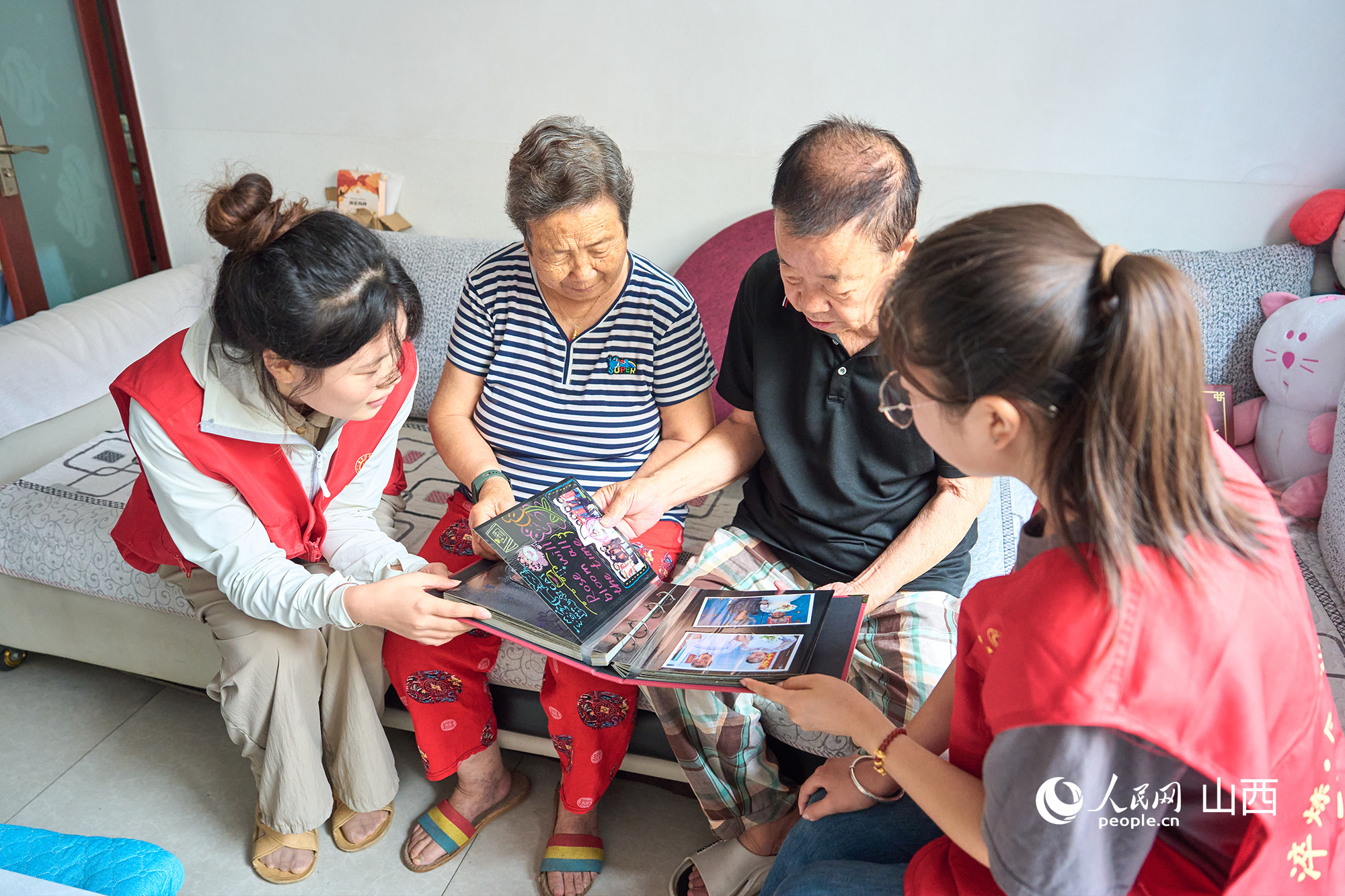 志愿者和老人一同看“時光紀”相冊。張超寧攝